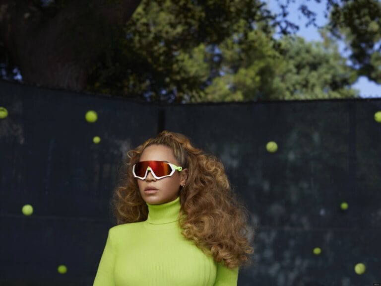 Beyoncé: Wears a fitted neon green sweater with a high neck that highlights her…