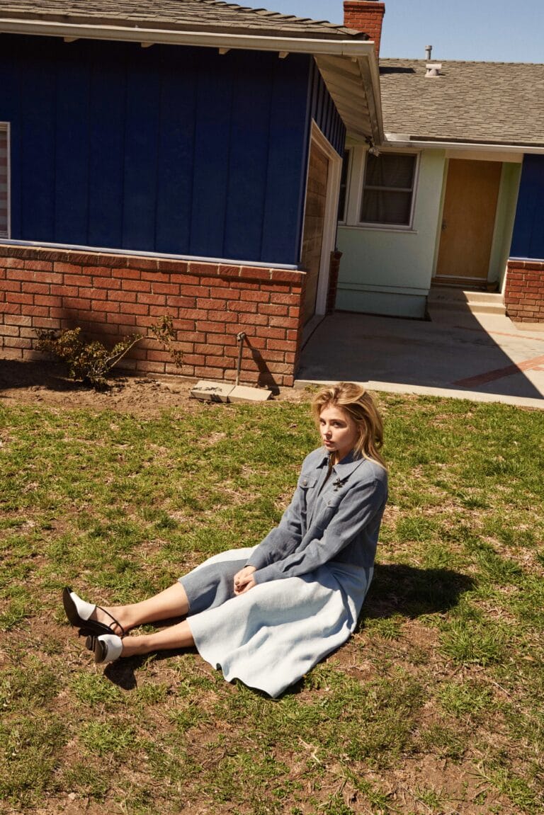 Chloë Grace Moretz: Sits on the grass, wearing a denim blouse with buttons and a…