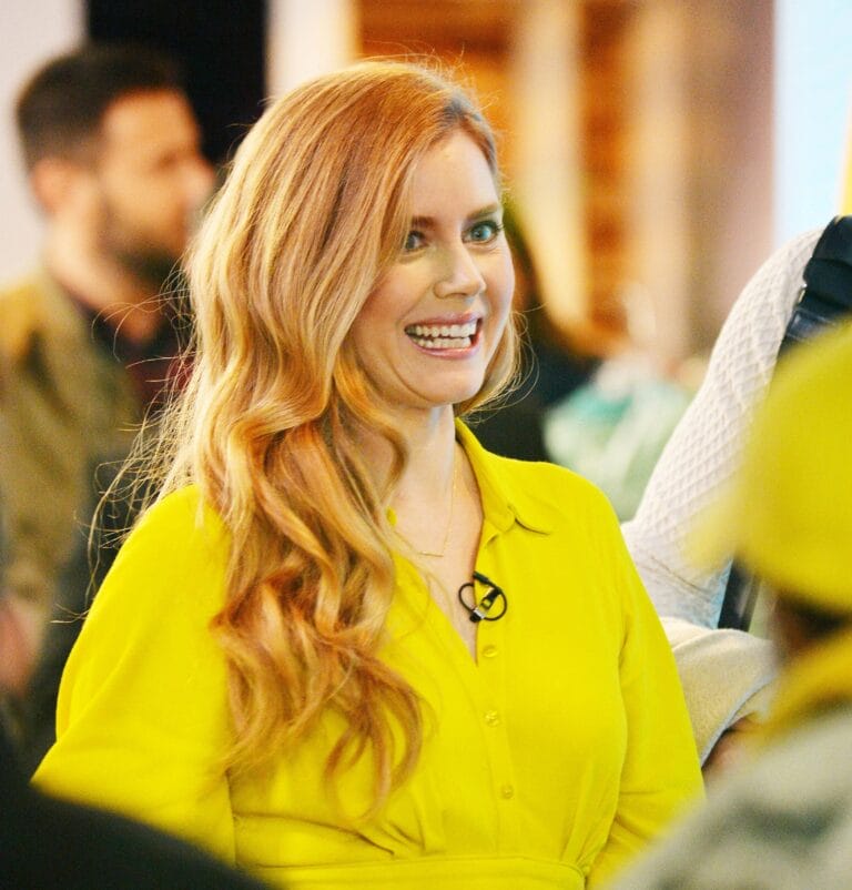 Amy Adams: Wears a vibrant yellow blouse with a relaxed fit, smiling enthusiastically at a…