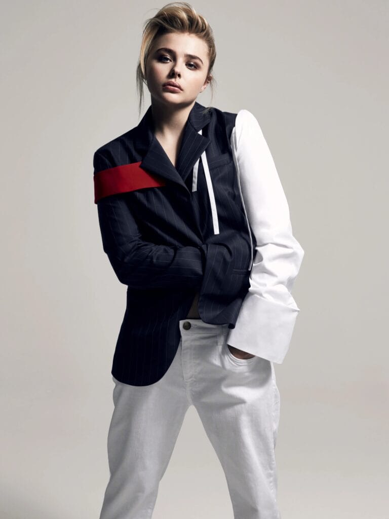 Chloë Grace Moretz: Wears an asymmetric blazer, with one side in navy stripes and one white sleeve,…