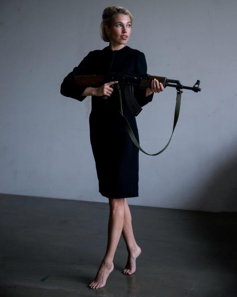 Thea Sofie Loch Næss: Wears a fitted black dress, elegant and classically cut, while holding a…