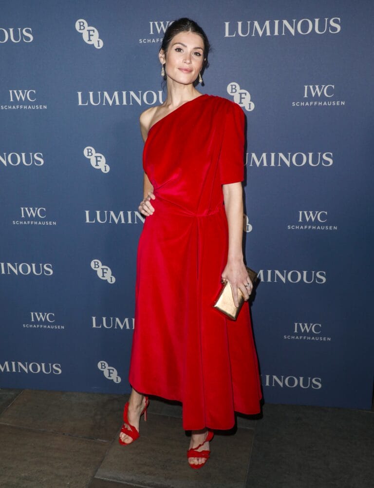 Gemma Arterton: Luce un vestido rojo de una sola manga, que cae elegantemente hasta las rodillas.…