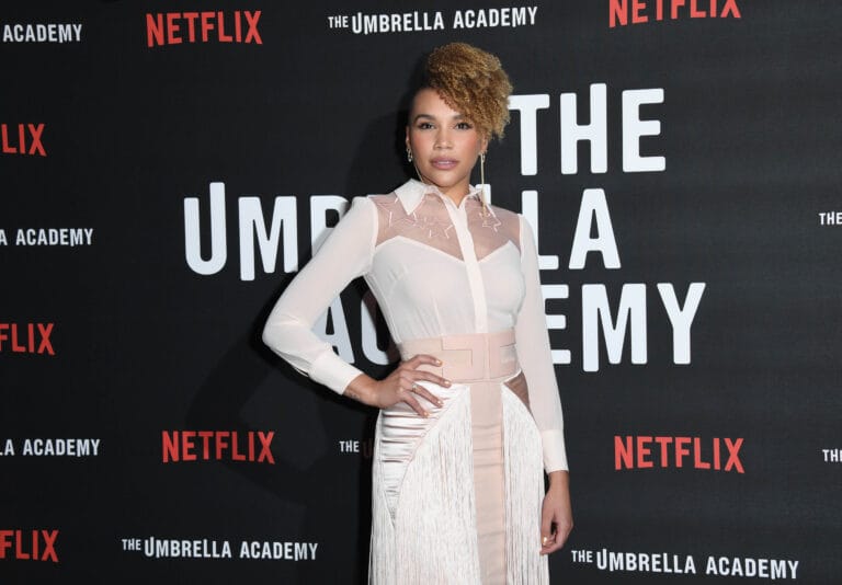 Emmy Raver-Lampman: Wears a sheer silk blouse with neckline details and a skirt…