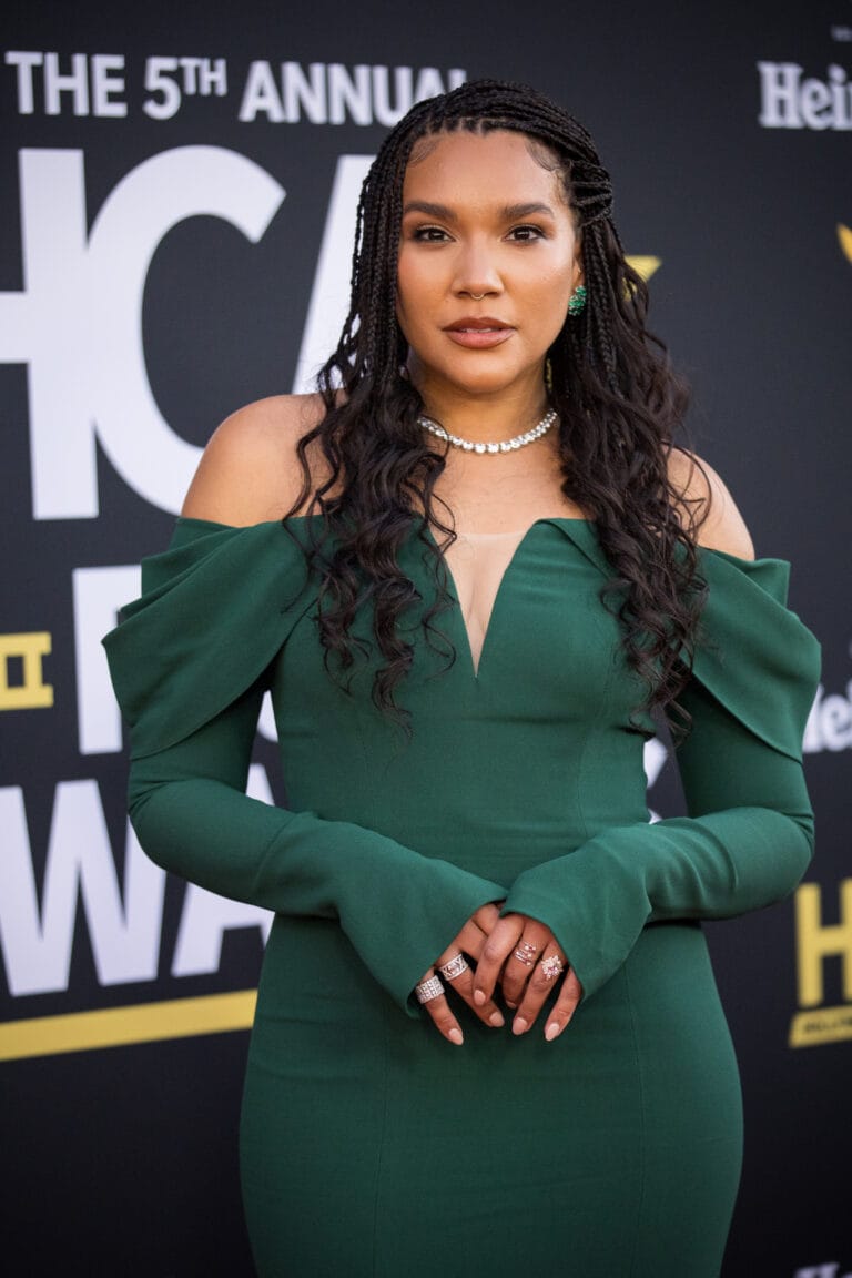 Emmy Raver-Lampman: Wears a fitted emerald green dress with long sleeves and voluminous details…