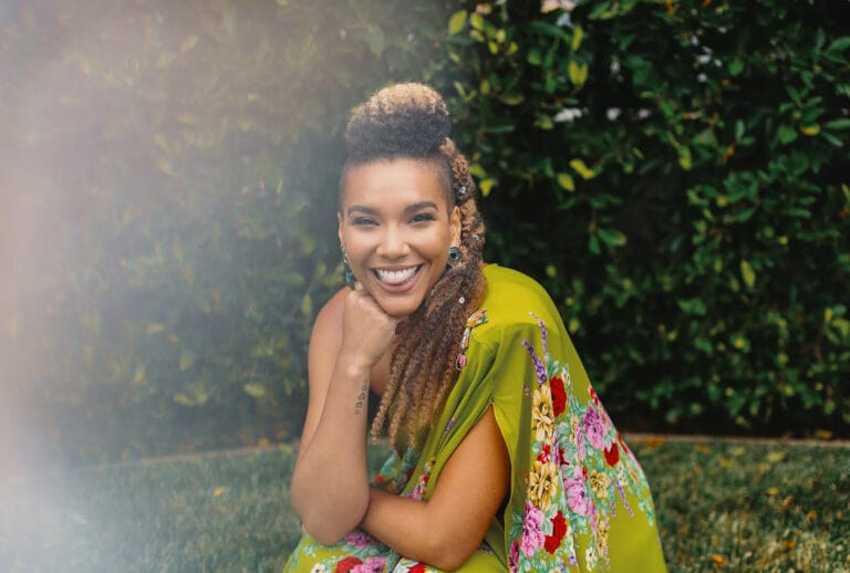 Emmy Raver-Lampman: Wears a vibrant green dress with a floral print, posing on a grassy surface.…