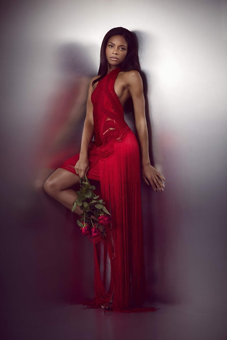 Naomie Harris: She wears a red fringed dress that flatters her figure, leaning against a wall…