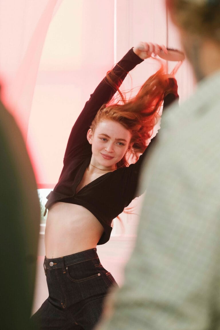 Sadie Sink: Wears a fitted black top that shows off her midriff and a pair of jeans…