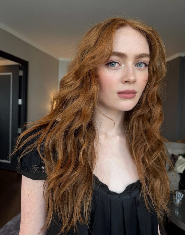 Sadie Sink: Luce una blusa negra con detalles de encaje en las mangas, que resalta su…