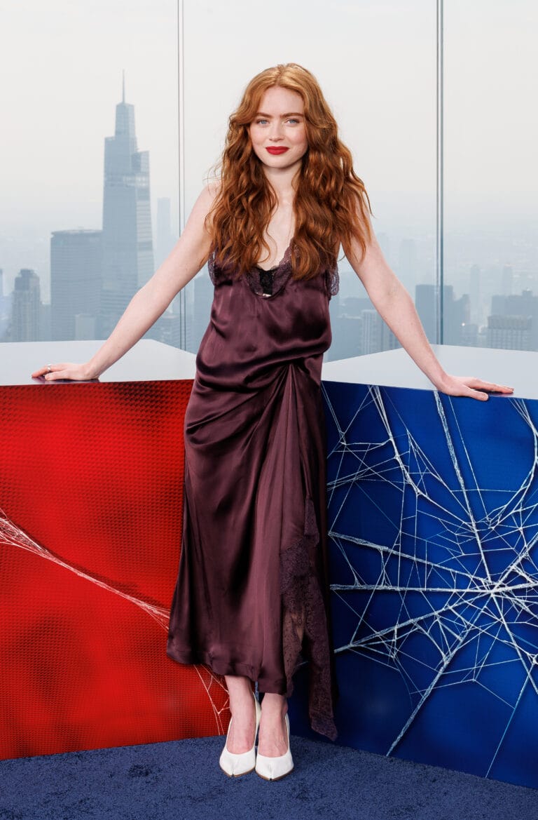 Sadie Sink: Wears a purple satin dress with lace details that falls softly over…