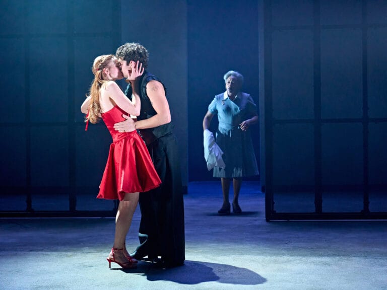 Sadie Sink: Is on a stage, caught in an intimate moment in a short red dress…