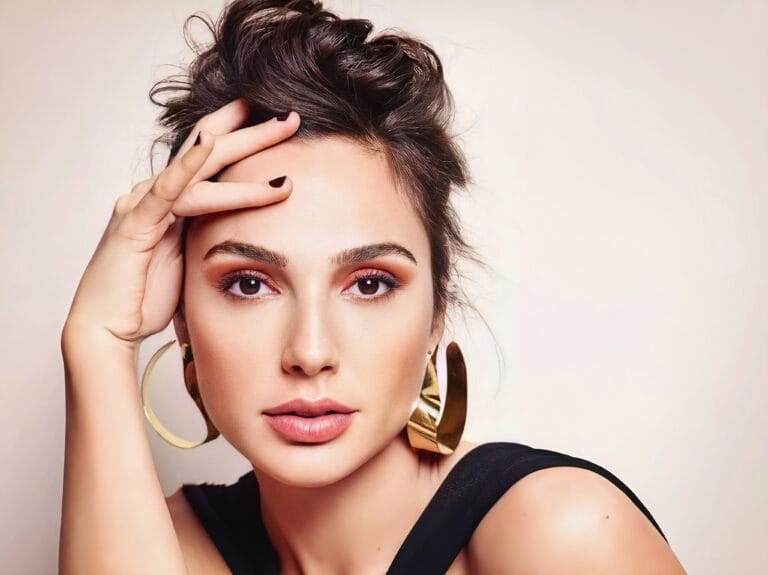 Gal Gadot: Wearing a black top with a wide strap and an elegant design that highlights her…