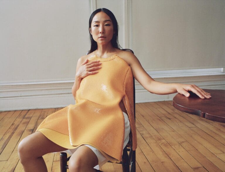 Greta Lee: Wears a bright yellow asymmetrical top that highlights her figure while…