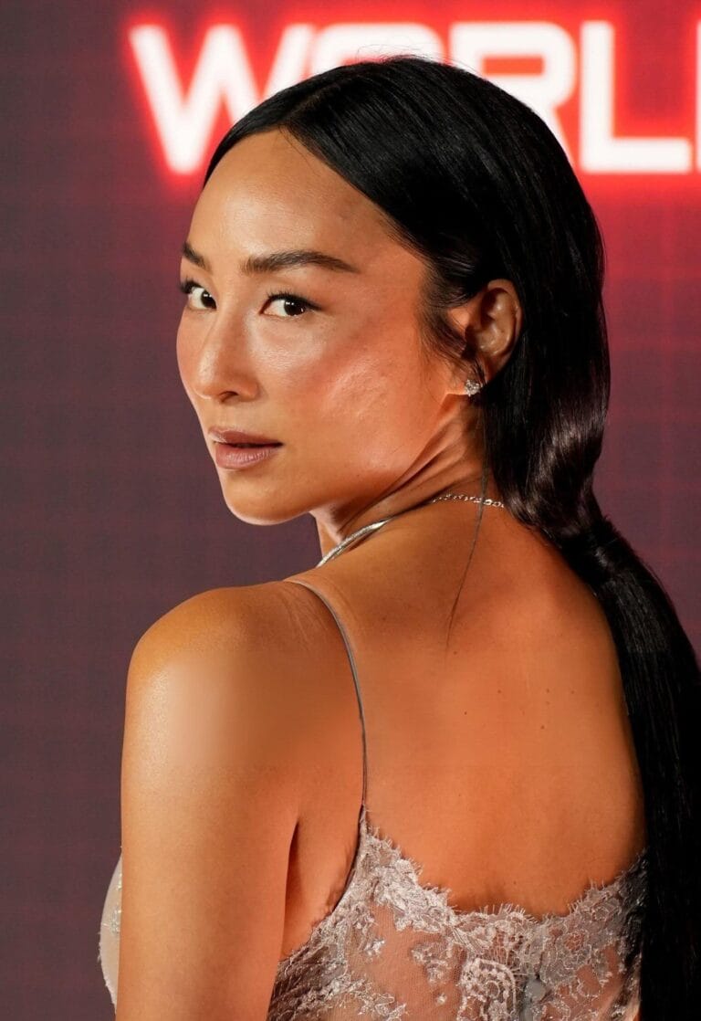 Greta Lee: Wears a sheer lace dress with delicate details that highlights her figure and…