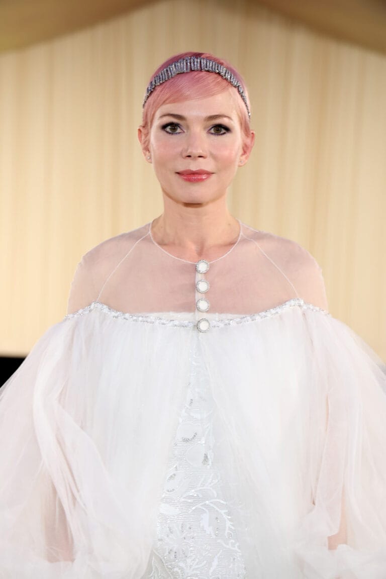Michelle Williams: Wears an ethereal white dress with an elegant detail at the top, adorned…