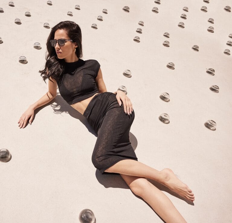 Kelsey Asbille: Wearing a black two-piece set with a cropped top and a skirt…