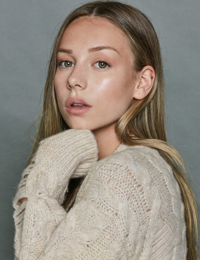 Ester Expósito: Wearing a beige wool sweater with a braided design that gives a…