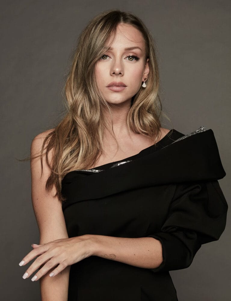 Ester Expósito: Wearing an asymmetrical black dress with an elegant shoulder detail that adds…