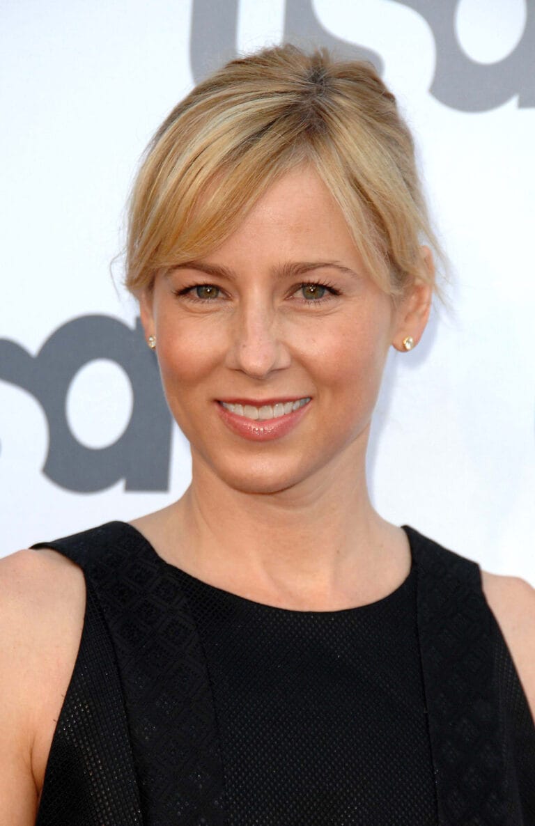 Traylor Howard: Wears a sleeveless black dress with a textured design that highlights her elegance.…