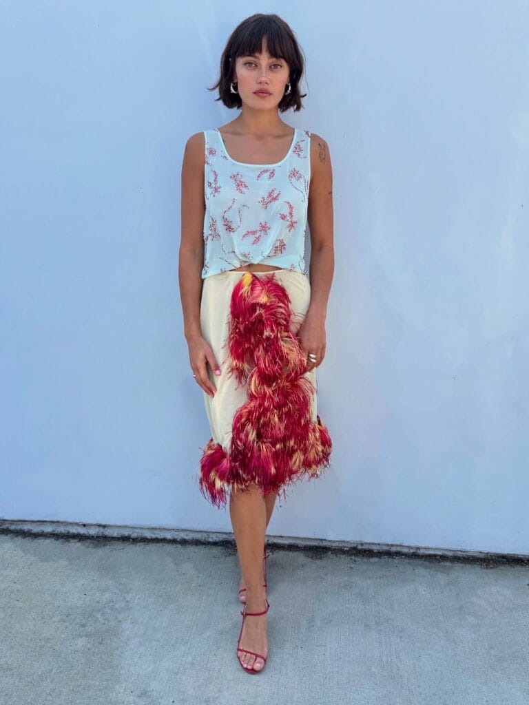 Ella Purnell: Wears a sleeveless light blue top with delicate embroidery, paired with…