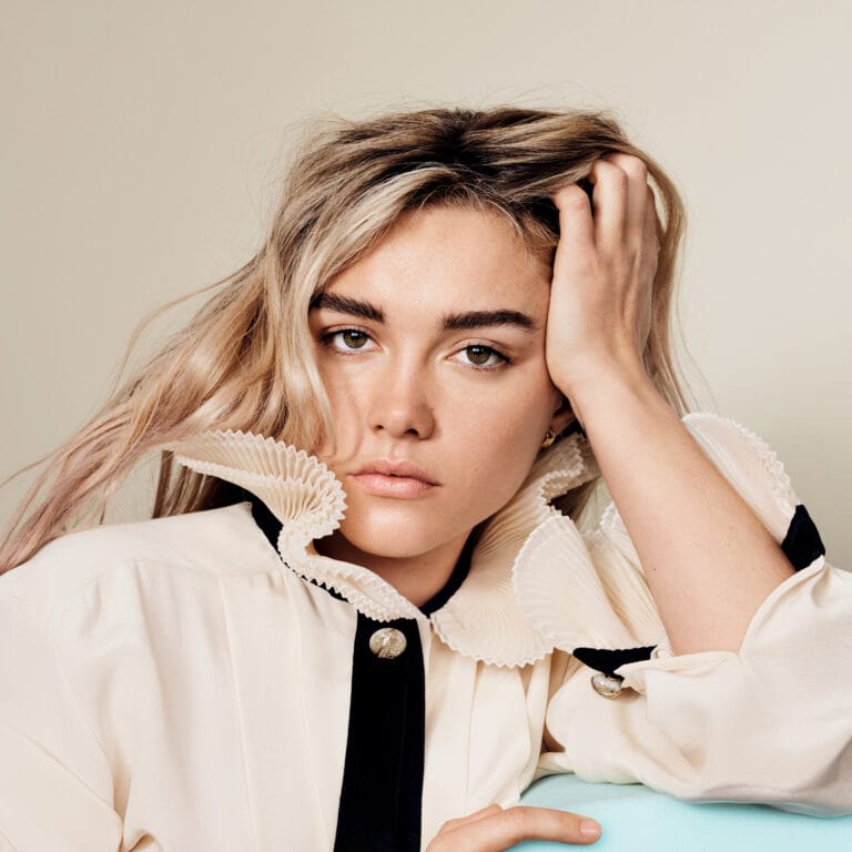 Florence Pugh: Luce una blusa de seda beige con un collar fruncido y detalles en negro,…
