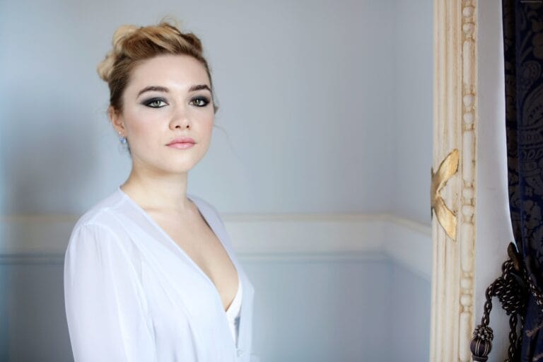 Florence Pugh: Luce una blusa blanca de corte suave con un escote pronunciado, combinando elegancia y…