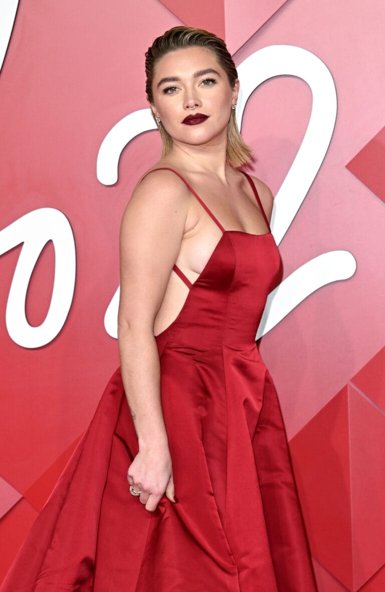 Florence Pugh: Luce un vestido rojo de corte asimétrico, que destaca por su escote profundo y…