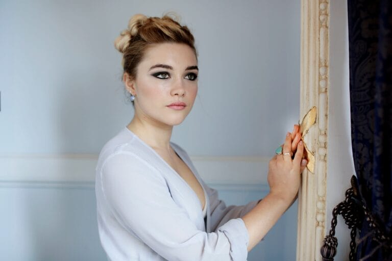 Florence Pugh: Posa frente a un espejo, luciendo una blusa transparente de tono suave que acentúa…