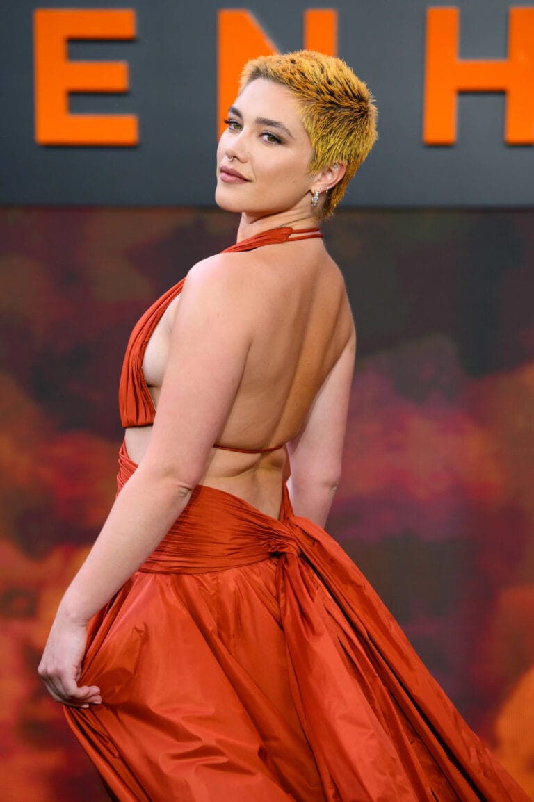 Florence Pugh: Luce un vestido largo de satén en un vibrante tono naranja, con un diseño…