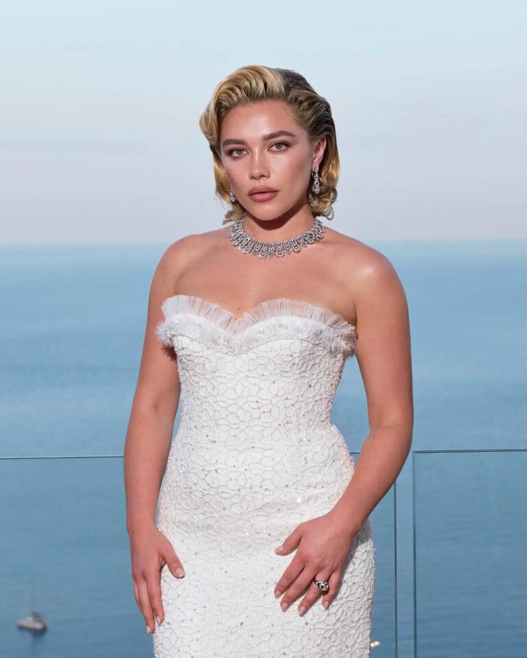 Florence Pugh: Wears an elegant white strapless dress with lace details and a subtle ruffle…