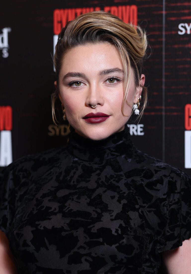Florence Pugh: Wears an elegant black velvet dress with a subtle design that highlights her…