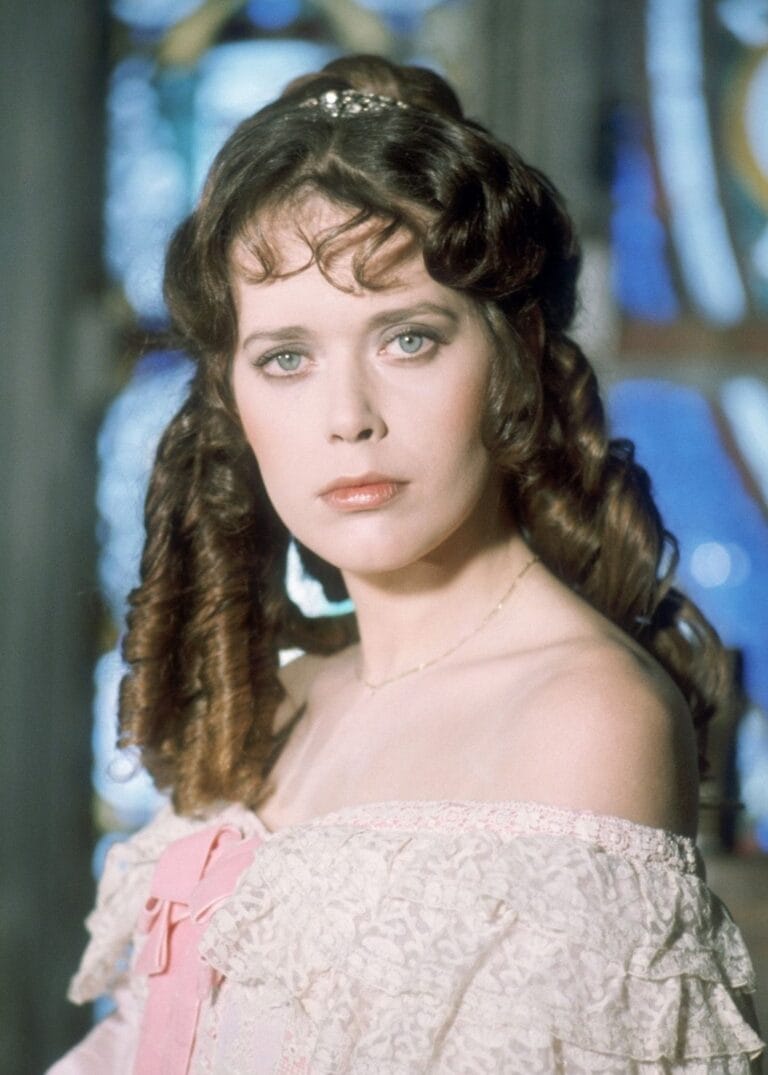 Sylvia Kristel: Wears a period dress in soft tones, with lace details and a…