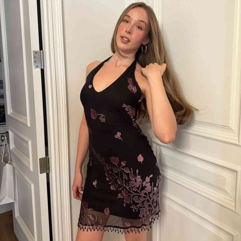 Ella Beatty: Wears a black dress with delicate purple embroidery that accentuates her figure.…
