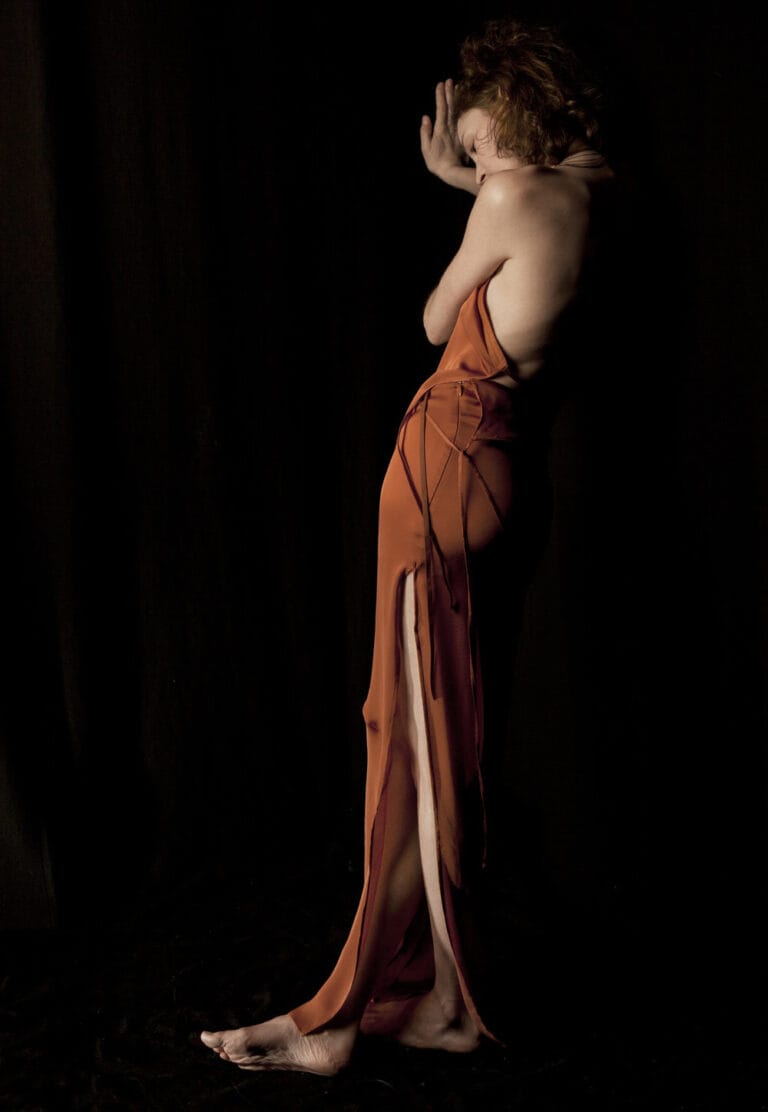 Vicky Krieps: Wears a long terracotta silk dress with a design that reveals…