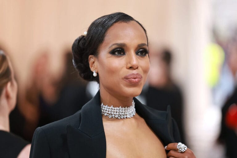 Kerry Washington: Wears an elegant black coat with a plunging neckline, revealing a pearl necklace…