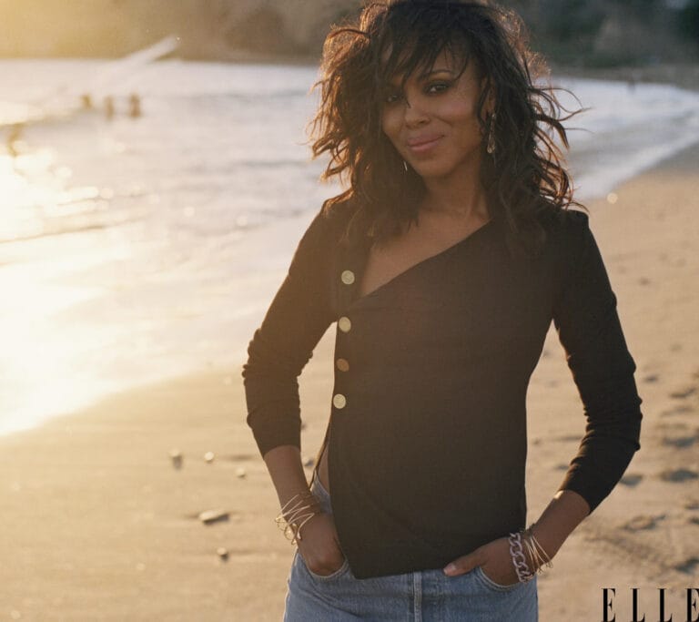 Kerry Washington: Wears a black one-shoulder blouse with gold buttons, paired with jeans…