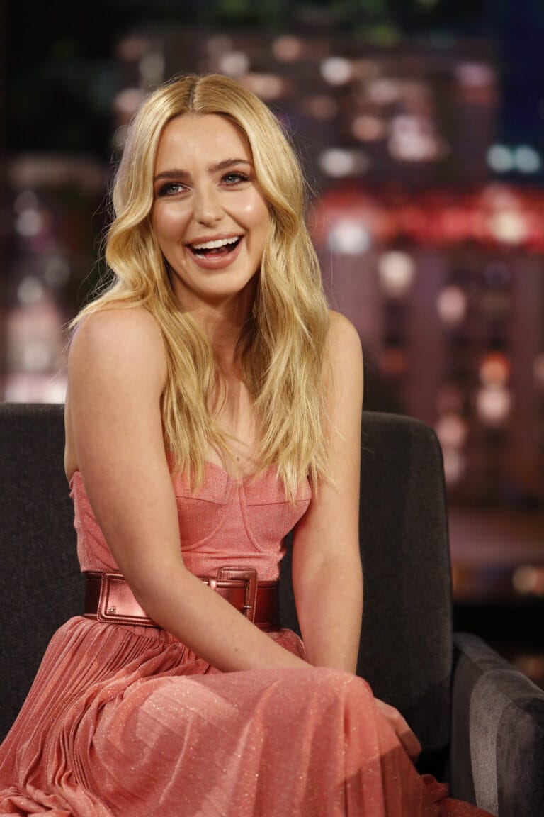 Jessica Rothe: Wears a long pink slip dress with a shiny belt at the…