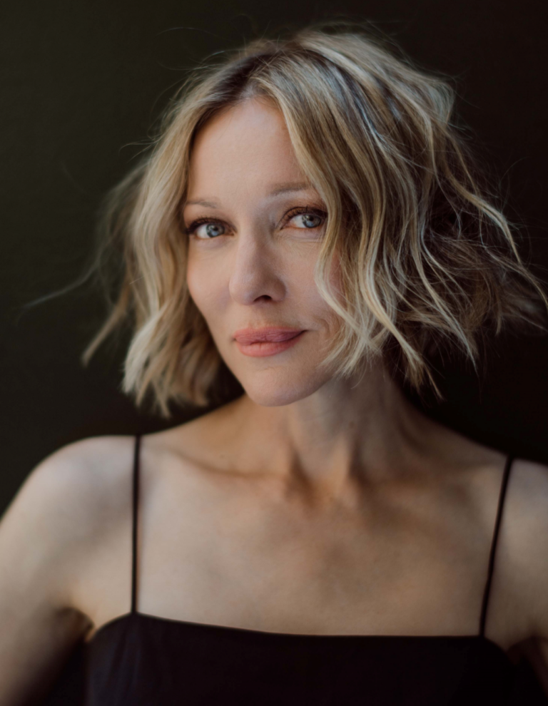 Kate Beahan: Wearing a black slip dress with thin straps that highlights her elegance and simplicity. She is…