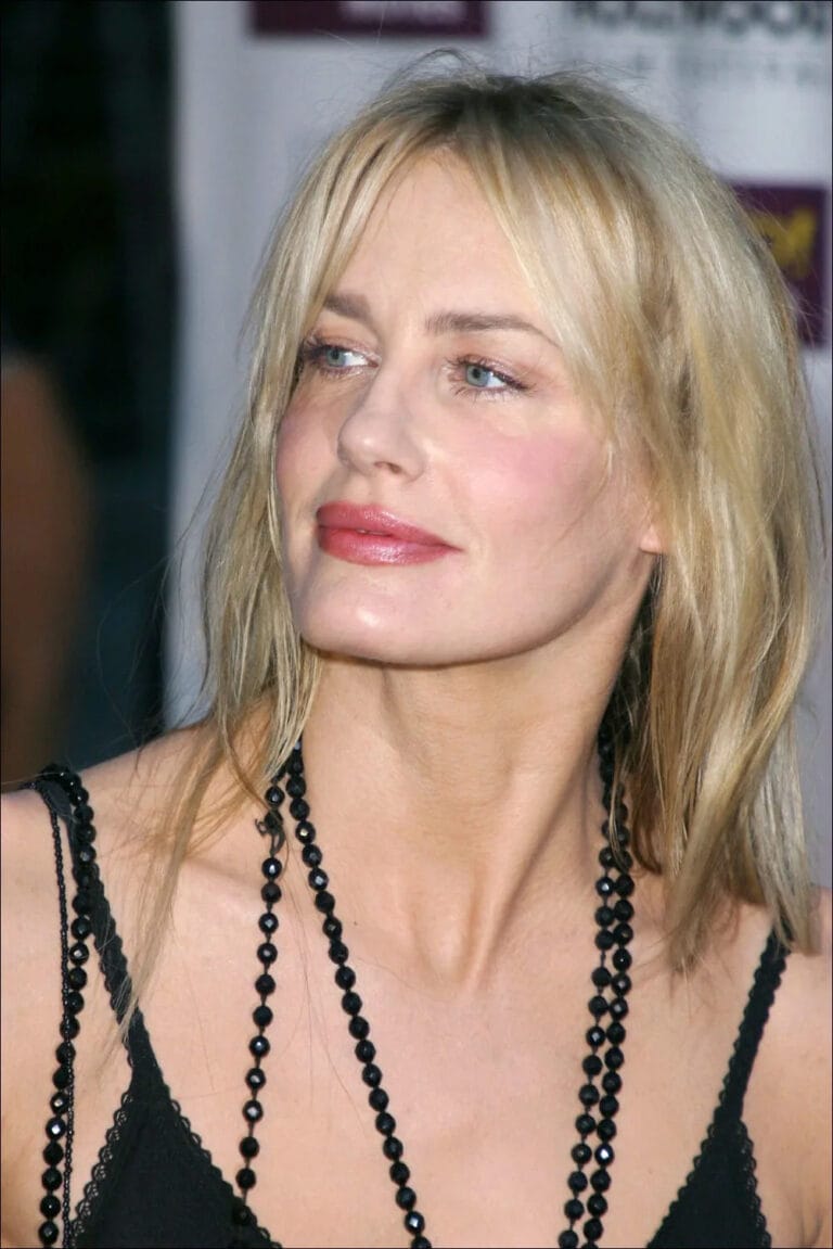 Daryl Hannah: Wears a black blouse with thin straps, highlighting her elegance and sophistication. She wears a…