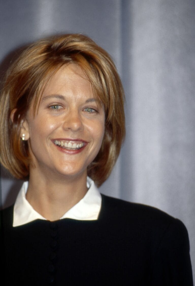 Meg Ryan: Wears a black blouse with an elegant white collar, smiling confidently at the…