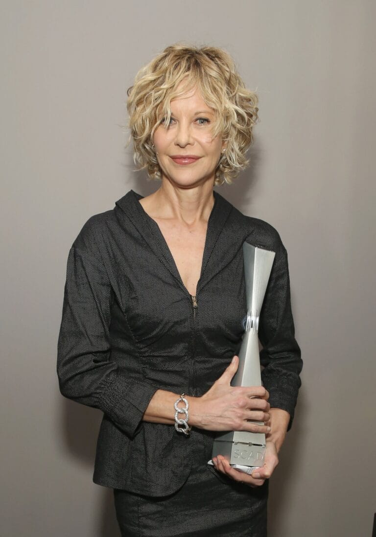 Meg Ryan: Wears a sleek black outfit with a modern design, paired with a jacket…