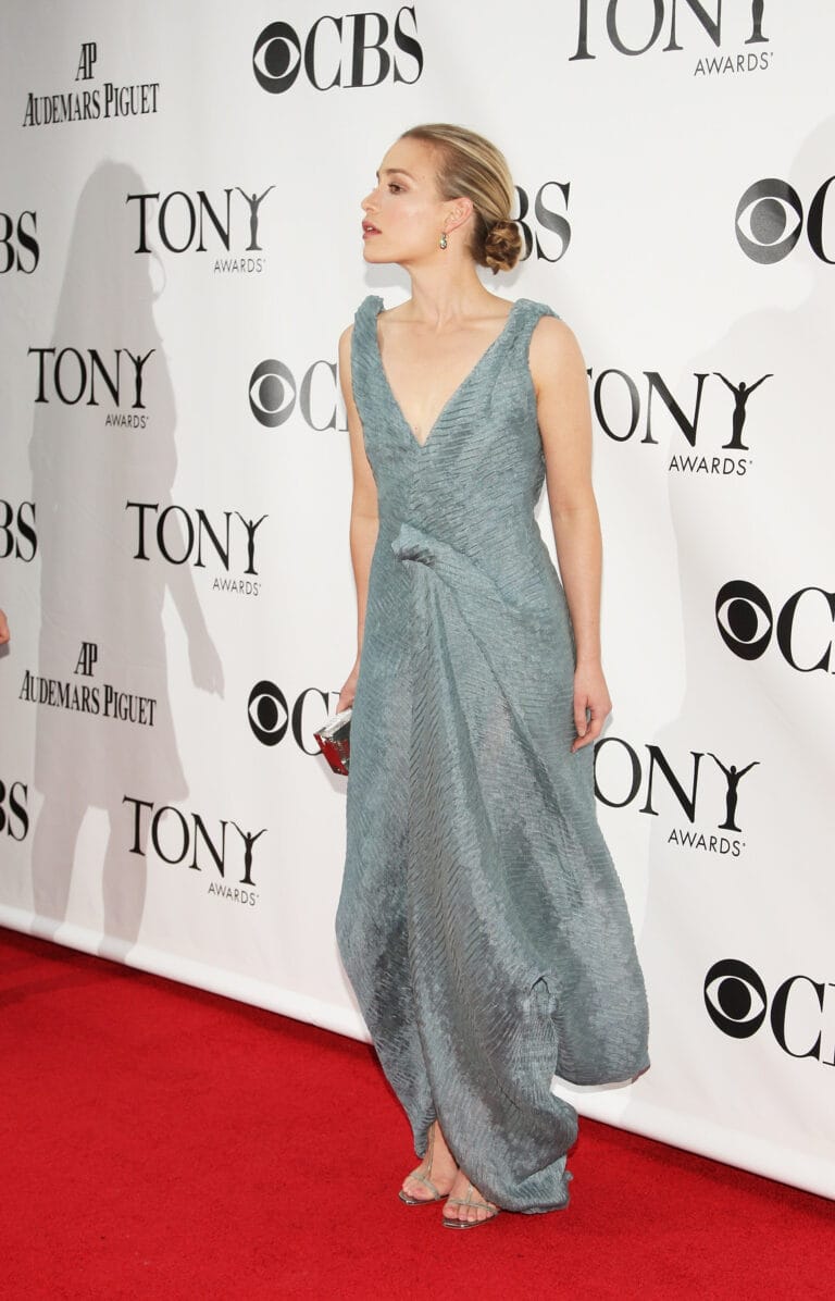 Piper Perabo: Wearing an elegant long light blue gown with a draped design that…