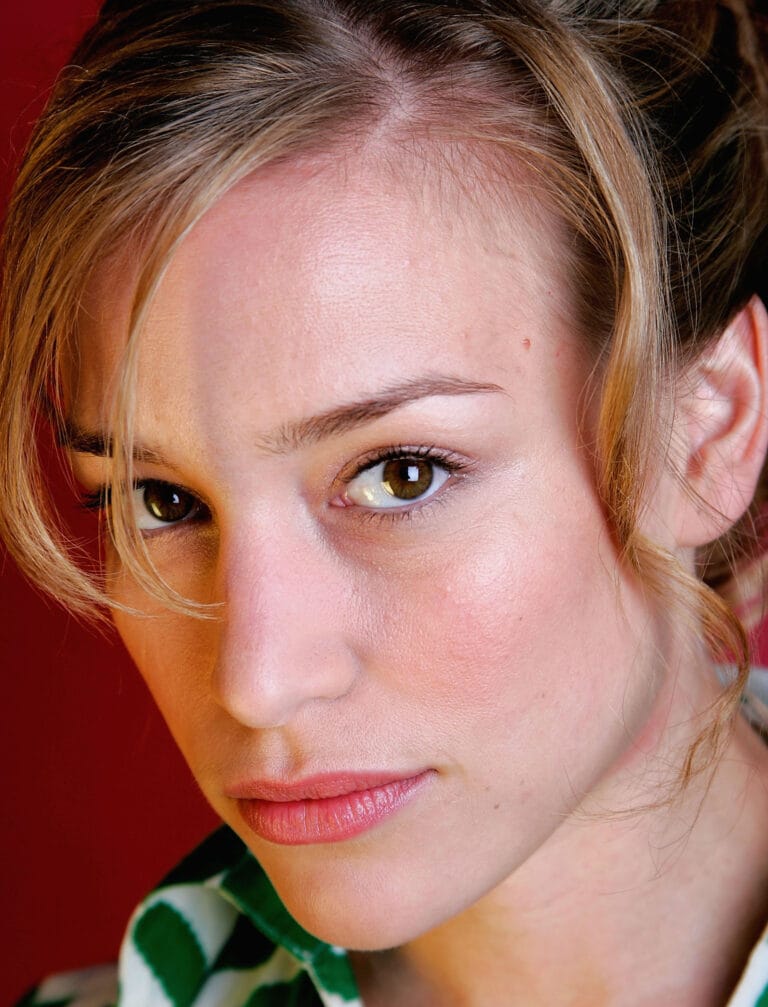 Piper Perabo: Wearing a green and white striped blouse with a fresh, casual style.…