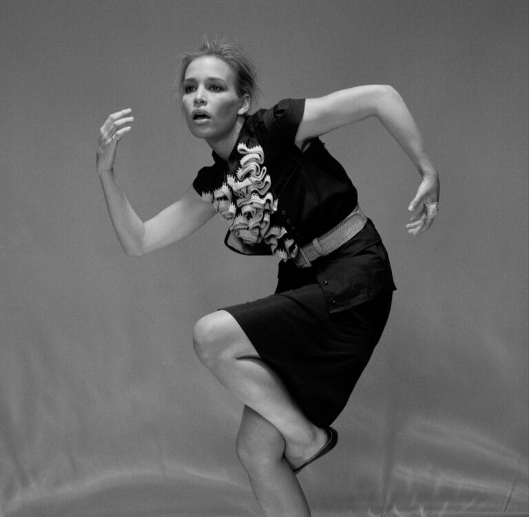 Piper Perabo: Poses dynamically in a fitted black dress with details…