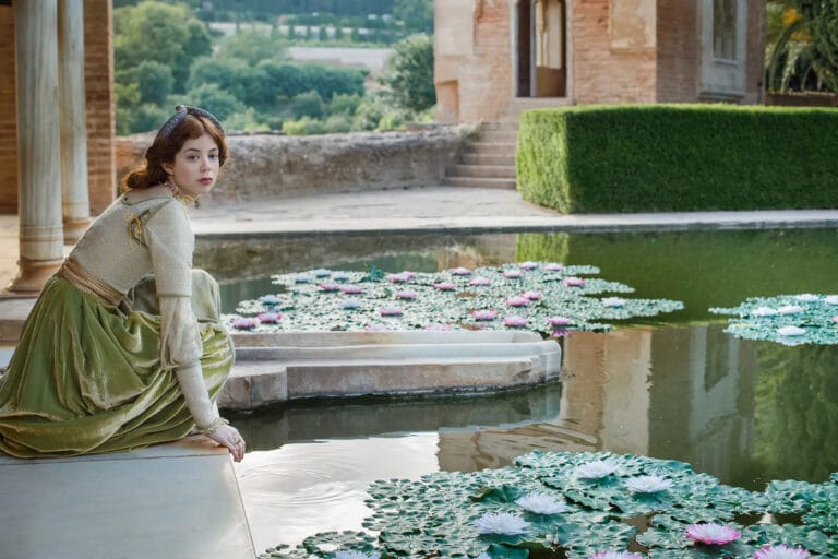 Charlotte Hope: Poses by a pond, wearing a green velvet dress with a corset…