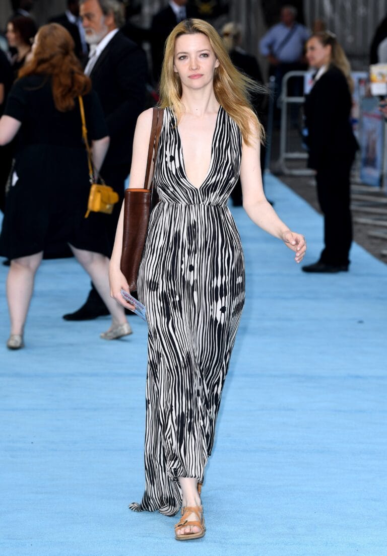 Talulah Riley: Camina con confianza sobre una alfombra azul, luciendo un vestido largo de rayas en…