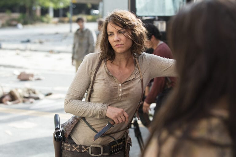 Lauren Cohan: Luce una camiseta de manga larga color beige, ligeramente desgastada, con un escote en…