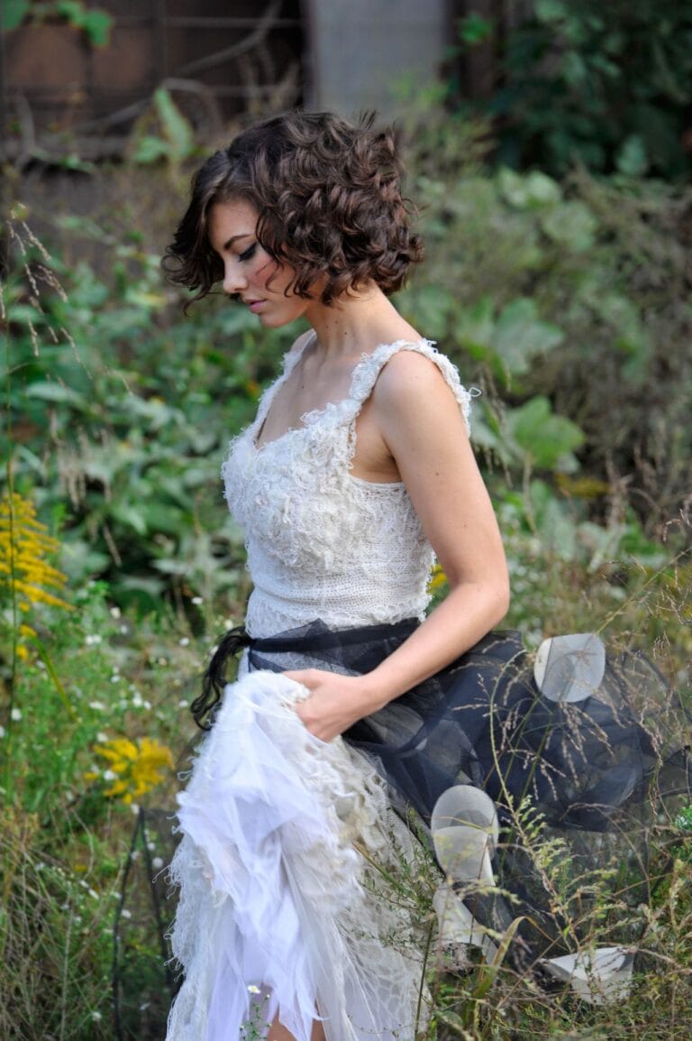 Lauren Cohan: Luce un vestido de encaje blanco con detalles texturizados, mientras se agacha ligeramente en…
