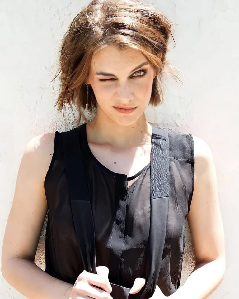 Lauren Cohan: Luce una blusa negra semitransparente con tirantes anchos, mostrando un estilo audaz y moderno.…