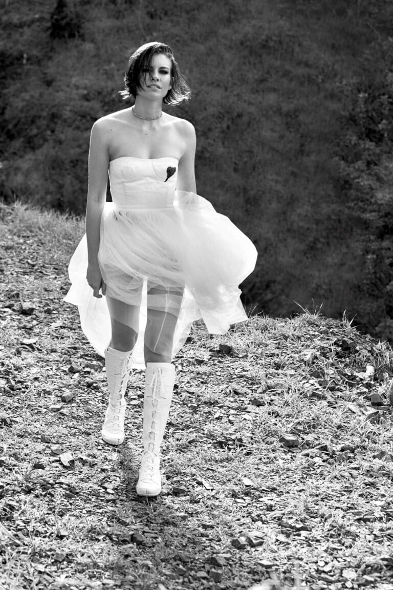 Lauren Cohan: Camina con determinación, luciendo un vestido strapless blanco con un toque de tul que…