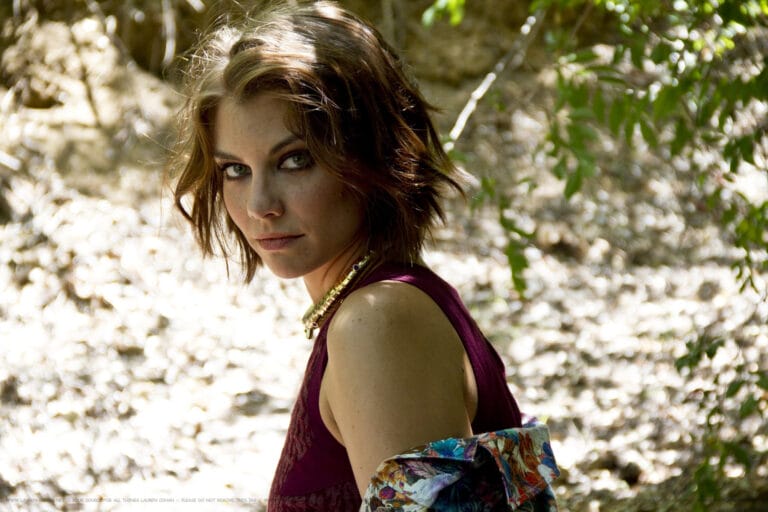Lauren Cohan: Luce una blusa sin mangas de color burdeos que resalta su figura, adornada con…